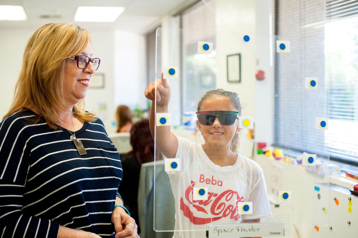 Analeina Lugo works with a space fixator under the guidance of certified optometric vision therapist Beth Houlihan. The space fixator helps determine whether a patient’s eyes see objects as closer or farther than they really are.