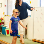 Teresa Richards, a certified optometric vision therapist, works with 6-year-old McKenzie Neufeld on an activity that combines balance and vision.