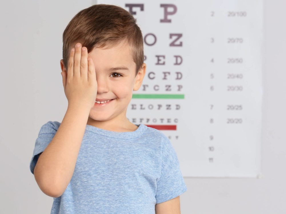 Cute little boy visiting children's doctor, space for text. Eye examination